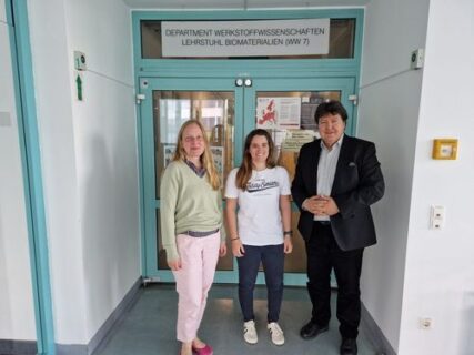 Prof. Boccaccini, Prof. Brauer and Dr. Chartier standing in the hall of the institute, looking at the camera.